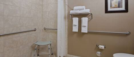 A bathroom with a shower, grab bars, a toilet, and a small step stool.