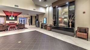 A hotel lobby with a reception desk, seating area, and a large window with a view. - Holiday Inn Oklahoma City North Quail Spgs by IHG (Oklahoma City)