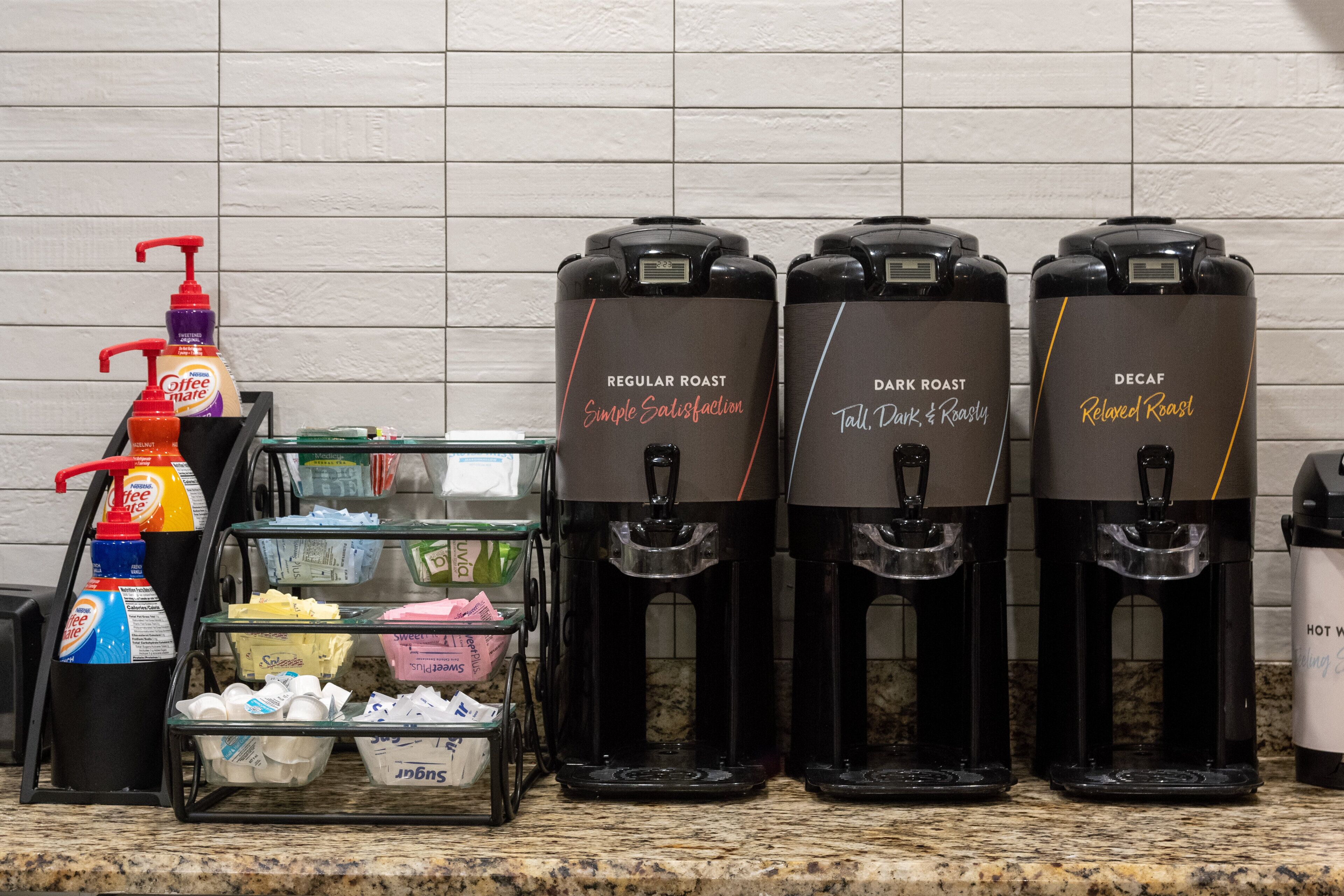 Three coffee dispensers labeled "Regular Roast," "Dark Roast," and "Decaf" on a kitchen counter.