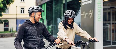 Deux personnes à vélo devant un hôtel appelé « Harry’s Home ».