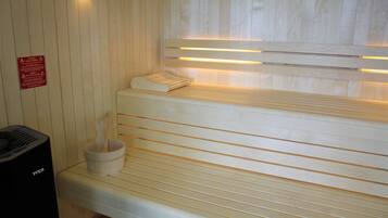 Un sauna avec des bancs en bois et un système de chauffage intégré aux bancs.