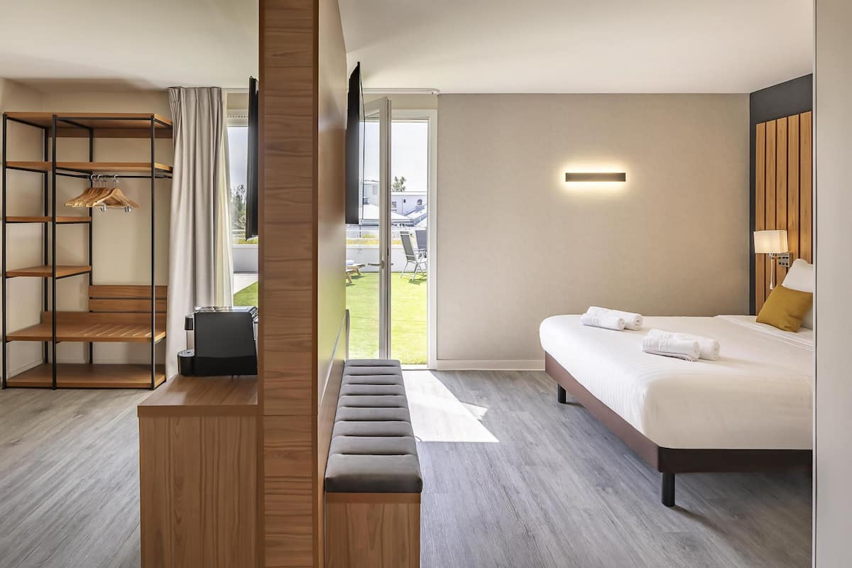 Une chambre d’hôtel comprenant un lit, un coin salon, une armoire et une vue sur l’extérieur.