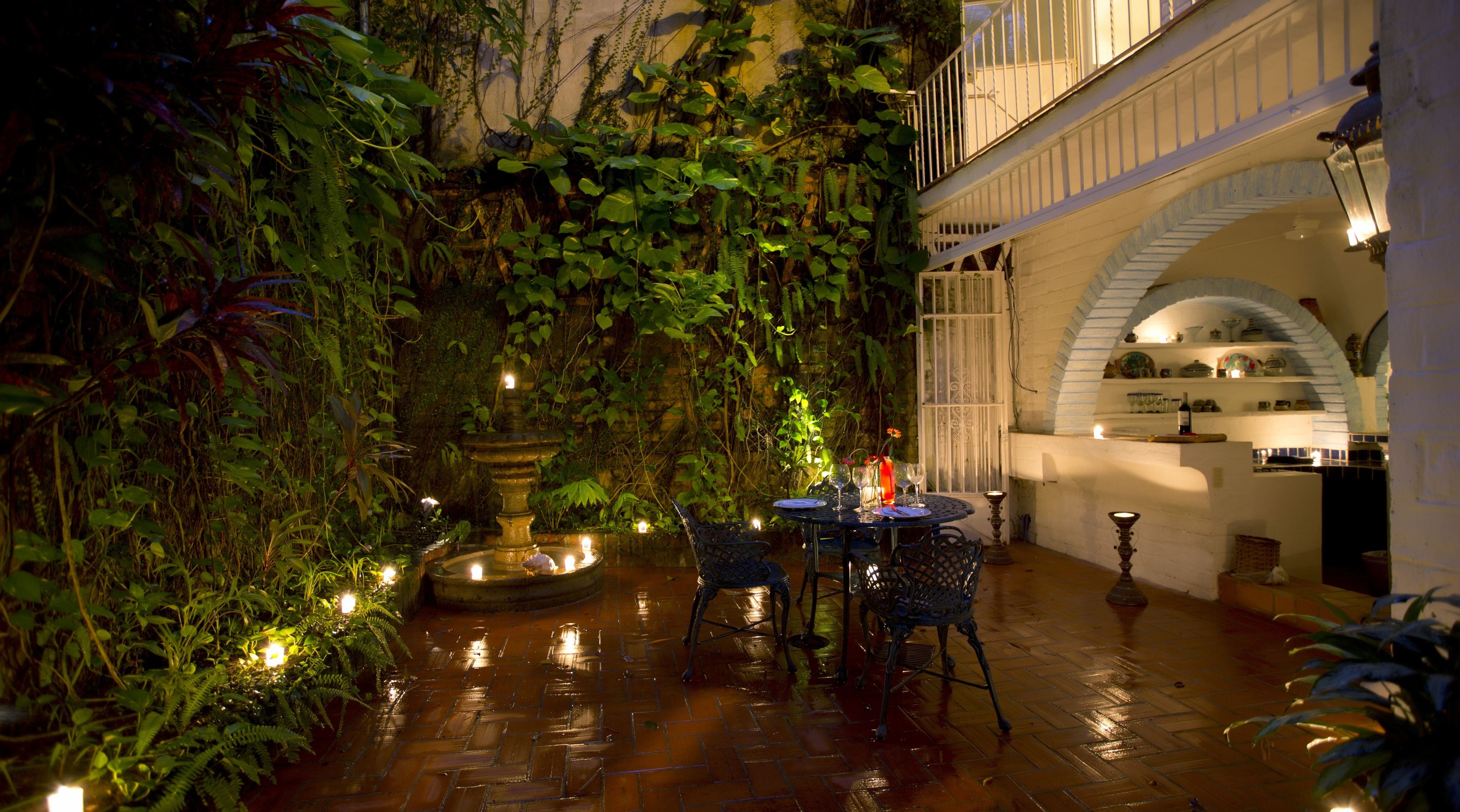 An indoor garden with a fountain, seating area, and a staircase.