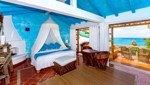 A bedroom with a bed, a table, and chairs, and a balcony with a view of the ocean. - Luna Líquida Hotel Boutique (Puerto Vallarta)