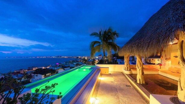 A poolside area with a view of the sea and a cityscape in the background. - Luna Líquida Hotel Boutique (Puerto Vallarta)