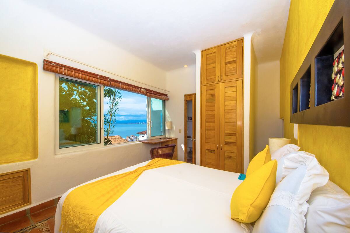 Ein Hotelzimmer mit Bett, Schreibtisch und Meerblick.