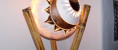 A decorative lamp with a moon and sun design, mounted on bamboo poles.