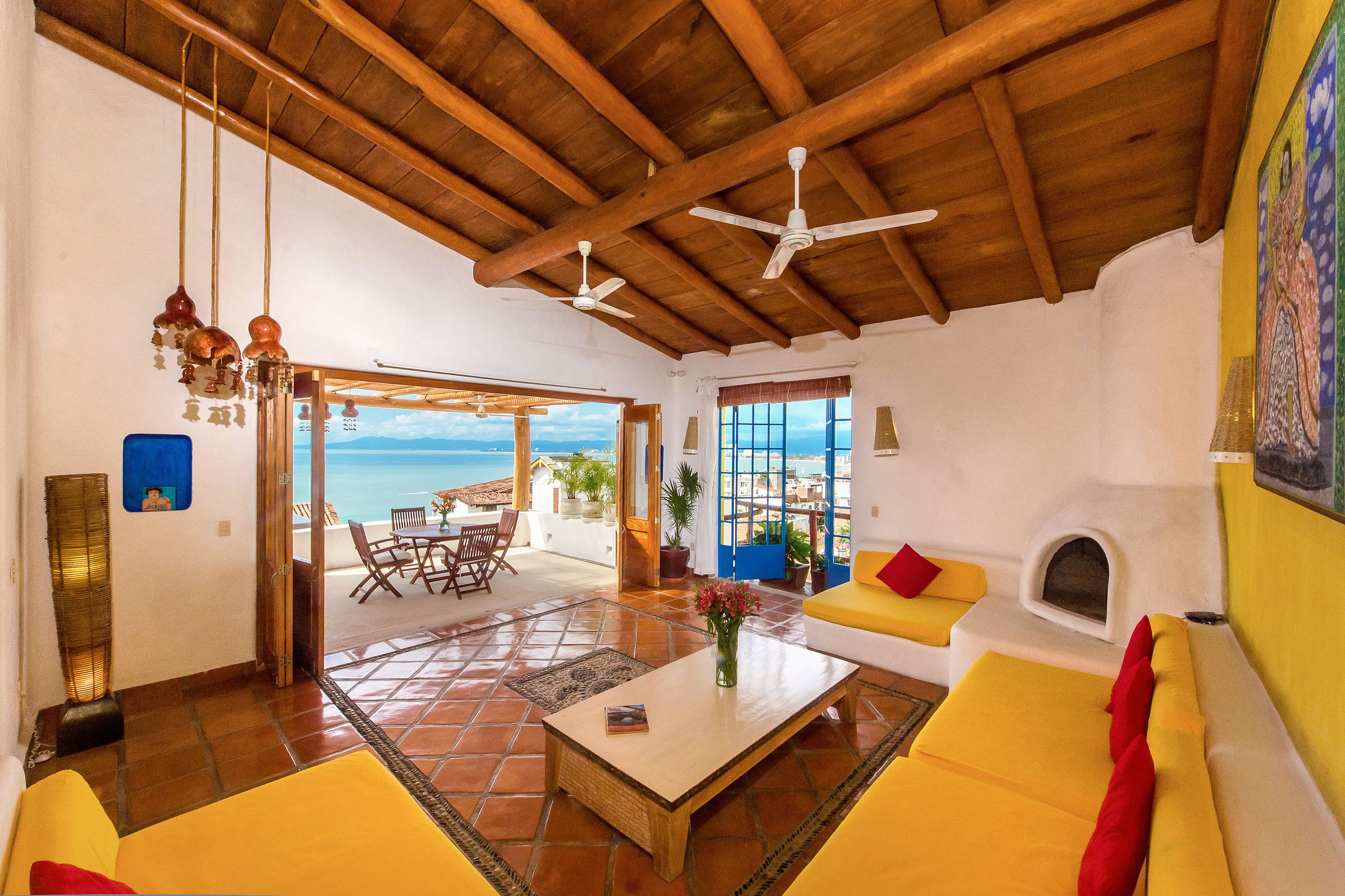 A spacious living area with a wooden ceiling, a sofa, a coffee table, and a fireplace.