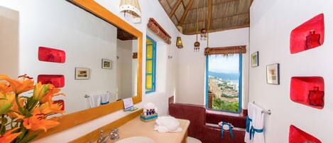 Un baño con un espejo grande, un lavabo, un inodoro y una ventana con vistas.