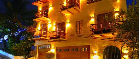 A multi-story building with balconies and a garage.