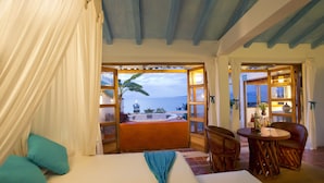 A room with a bed, a table with chairs, and a view of the sea. - Luna Líquida Hotel Boutique (Puerto Vallarta)