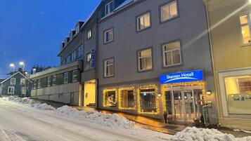 A hotel with a sign reading "Skansen Hotel" and a visible entrance.