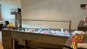 Ein Bereich mit einem Buffet und verschiedenen Speisen sowie einer digitalen Uhr.