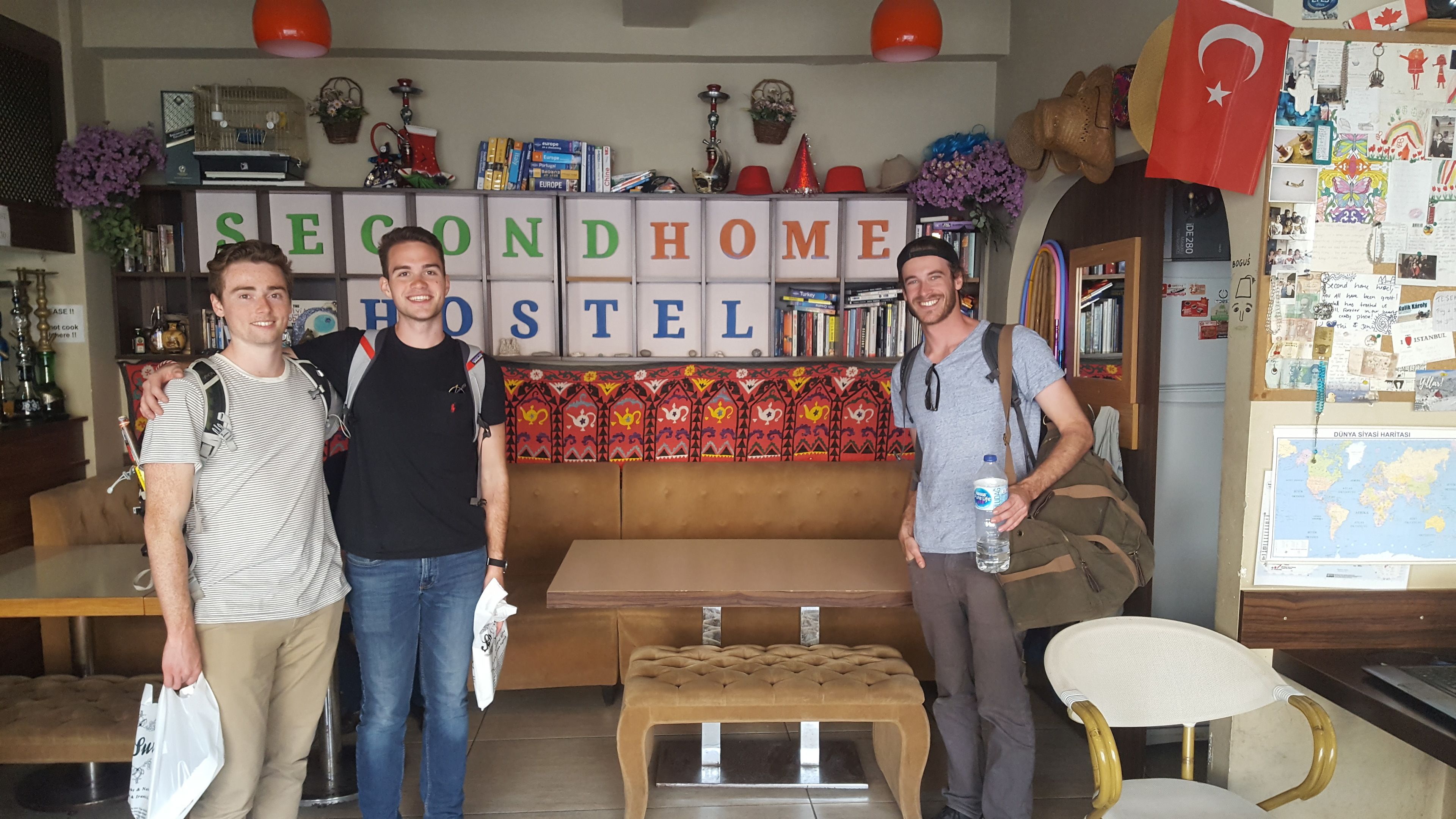 A hotel lobby with a sofa, a coffee table, and a wall displaying the words "SEONDHOME HOTEL".