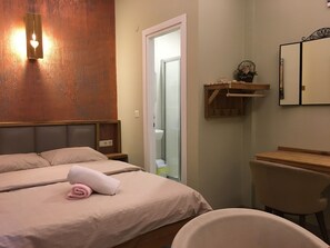 Un dormitorio con cama, mesitas de noche, una silla, un espejo y un estante de madera.