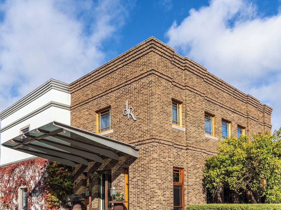 A brick building with a flat roof, a covered entrance, and a small window.