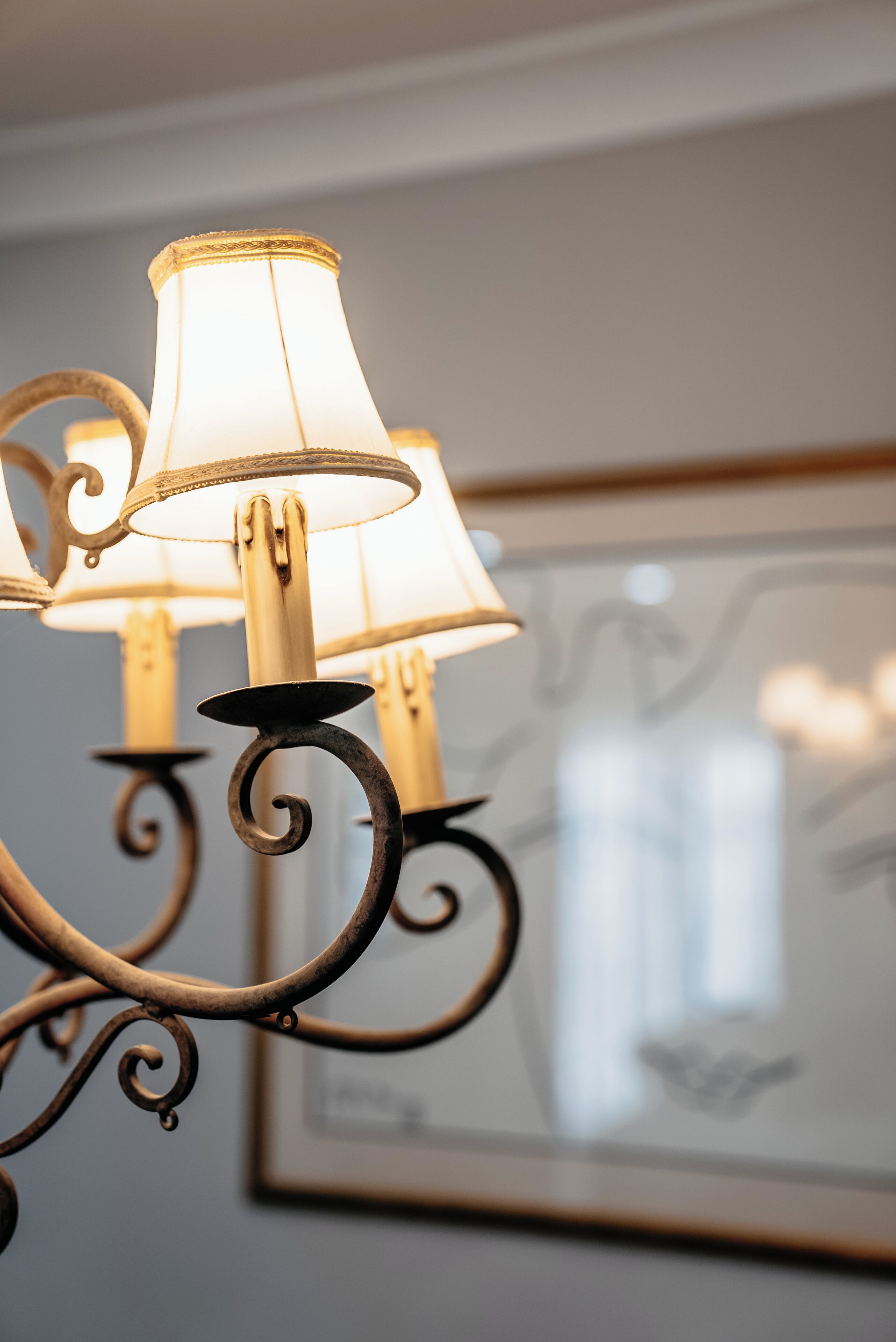 A chandelier with ornate metalwork and lampshades.