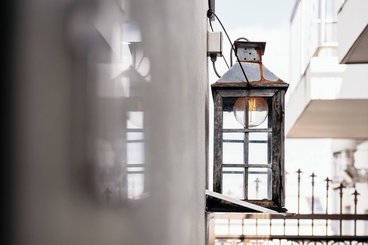 A view through a window with a metal gate and a lantern.