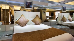 Una habitación de hotel con una cama grande, un televisor y un espejo.