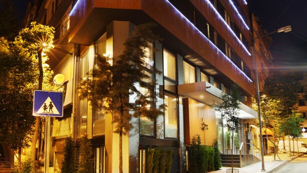Un edificio de varios pisos con letreros iluminados que indican “JAZZ HOTEL” en la fachada.