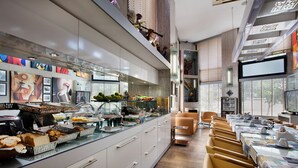 Un restaurante moderno con una barra alargada, varias zonas de estar y una variedad de alimentos exhibidos.