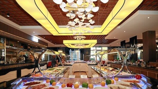 A buffet with various food options, a central seating area, and a modern chandelier. - Hotel & Restaurant Danner (Rheinfelden (Baden))