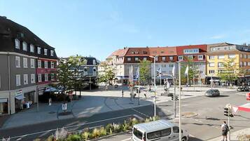 A city intersection with buildings, a van, and pedestrians.