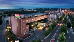 Un hotel con un giardino pensile, un ristorante e un ponte pedonale.