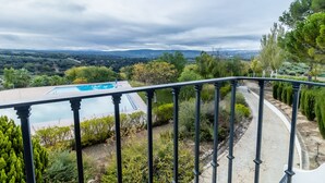 A balcony with a view of a swimming pool and surrounding greenery. - Hotel Las Errizas by Vivere Stays (Alcala del Valle)