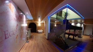 Ein modernes Interieur mit Holzboden, einer Glastrennwand und einer Treppe.
