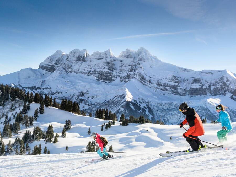 A snowy mountain landscape with skiers.