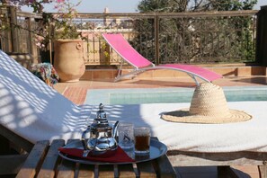 Een buitenzwembad en ligstoelen