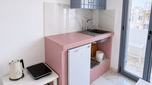 Una cucina compatta con lavastoviglie integrata, un piccolo piano di lavoro e una finestra vista su zona residenziale.