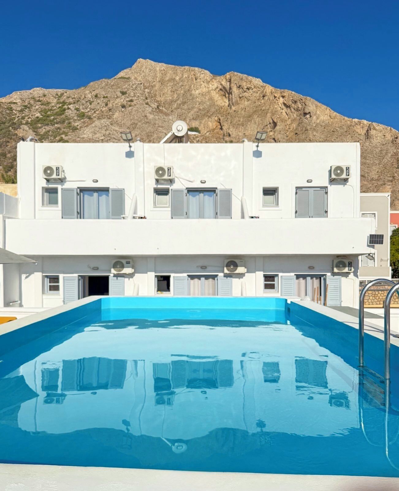 A two-story building with a swimming pool in front.