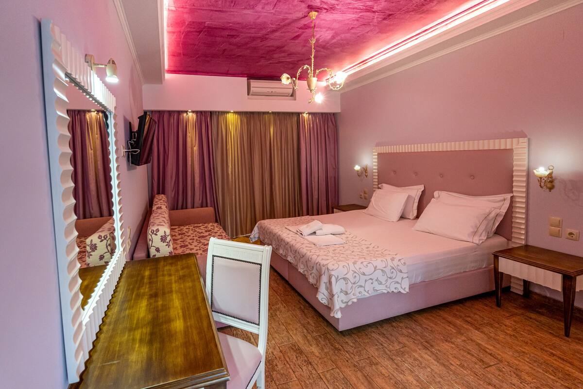 Un dormitorio con cama, escritorio y silla.