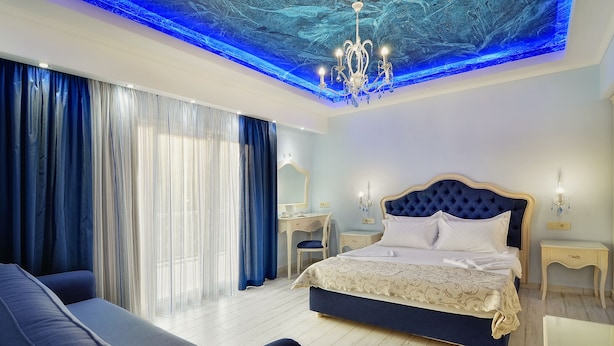 Un dormitorio moderno con una cama grande, un escritorio y una araña.