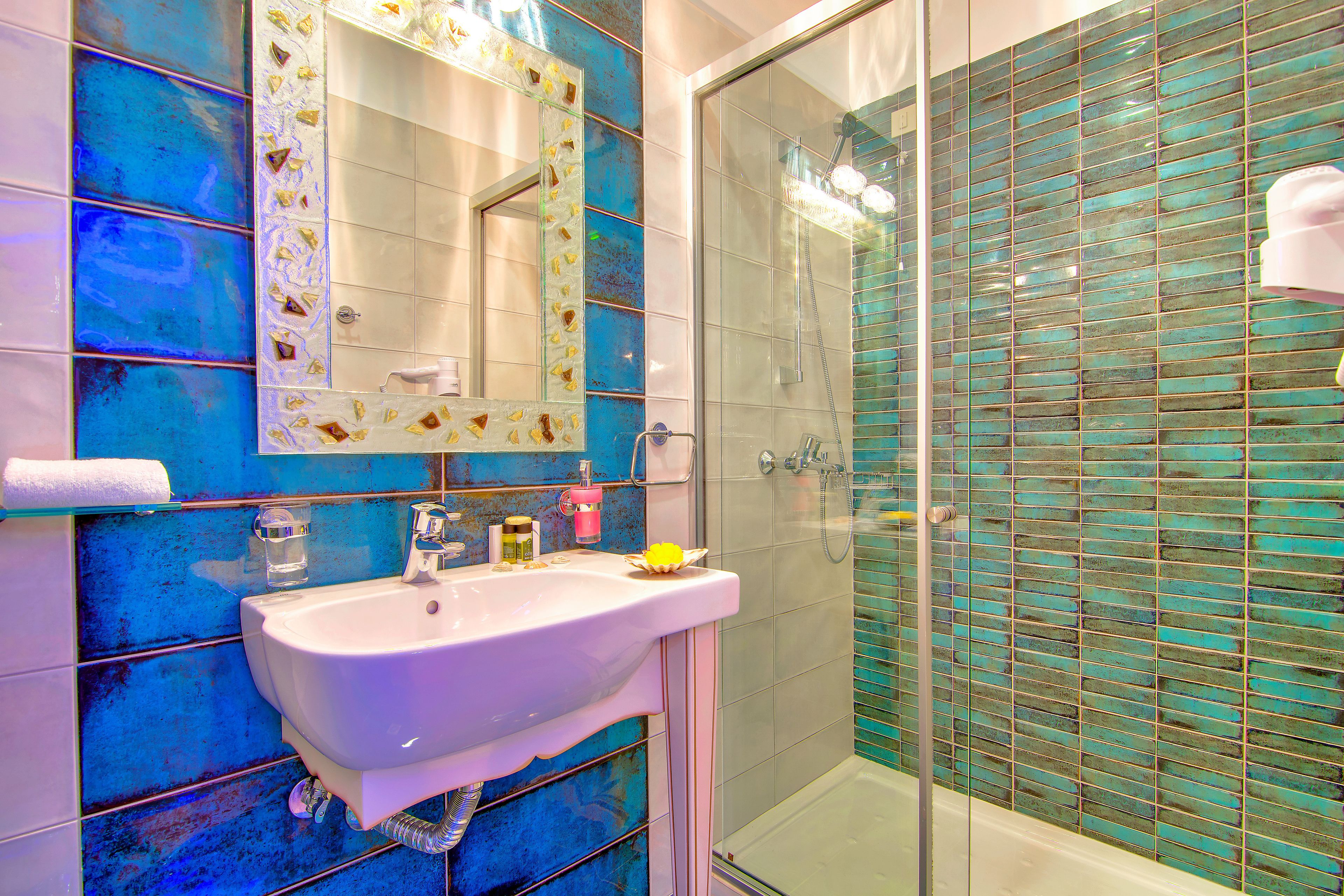 Baño con lavamanos, espejo y ducha.