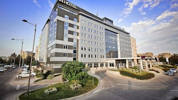 Situated in a well-maintained area, this hotel offers a modern, symmetrical facade with multiple windows and a flat roof.