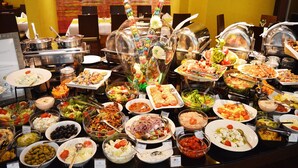 A buffet with various dishes and a decorative centerpiece.