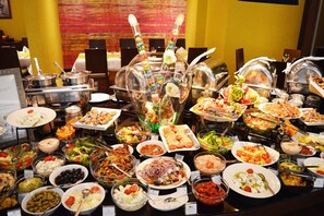A buffet with various dishes and a decorative centerpiece.