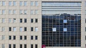A modern hotel building with a reflective glass facade and a sign reading "IN HOTEL".