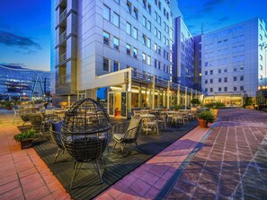 Un hotel moderno con terraza y fachada de vidrio.