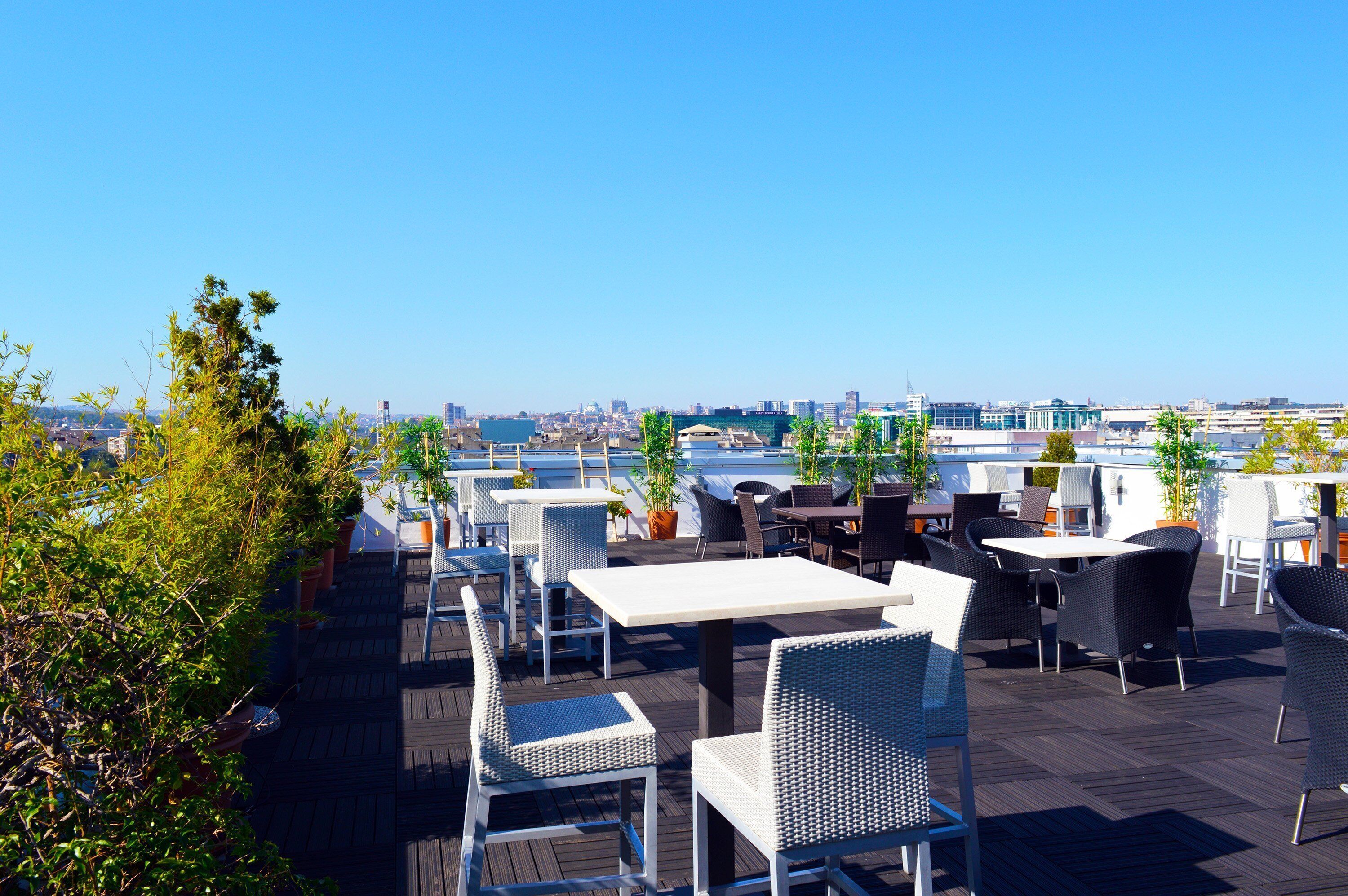 A rooftop terrace with outdoor seating and a city view.