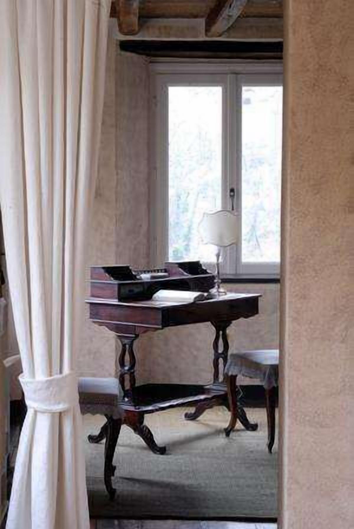 A room with a desk, a lamp, and a window.