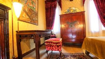 Una habitación tradicional con un escritorio de madera, un taburete acolchado rojo, un armario de madera grande y una alfombra estampada.
