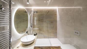 Ein modernes Badezimmer mit einem runden Spiegel, einer freistehenden Badewanne und einem großzügigen Waschbecken.