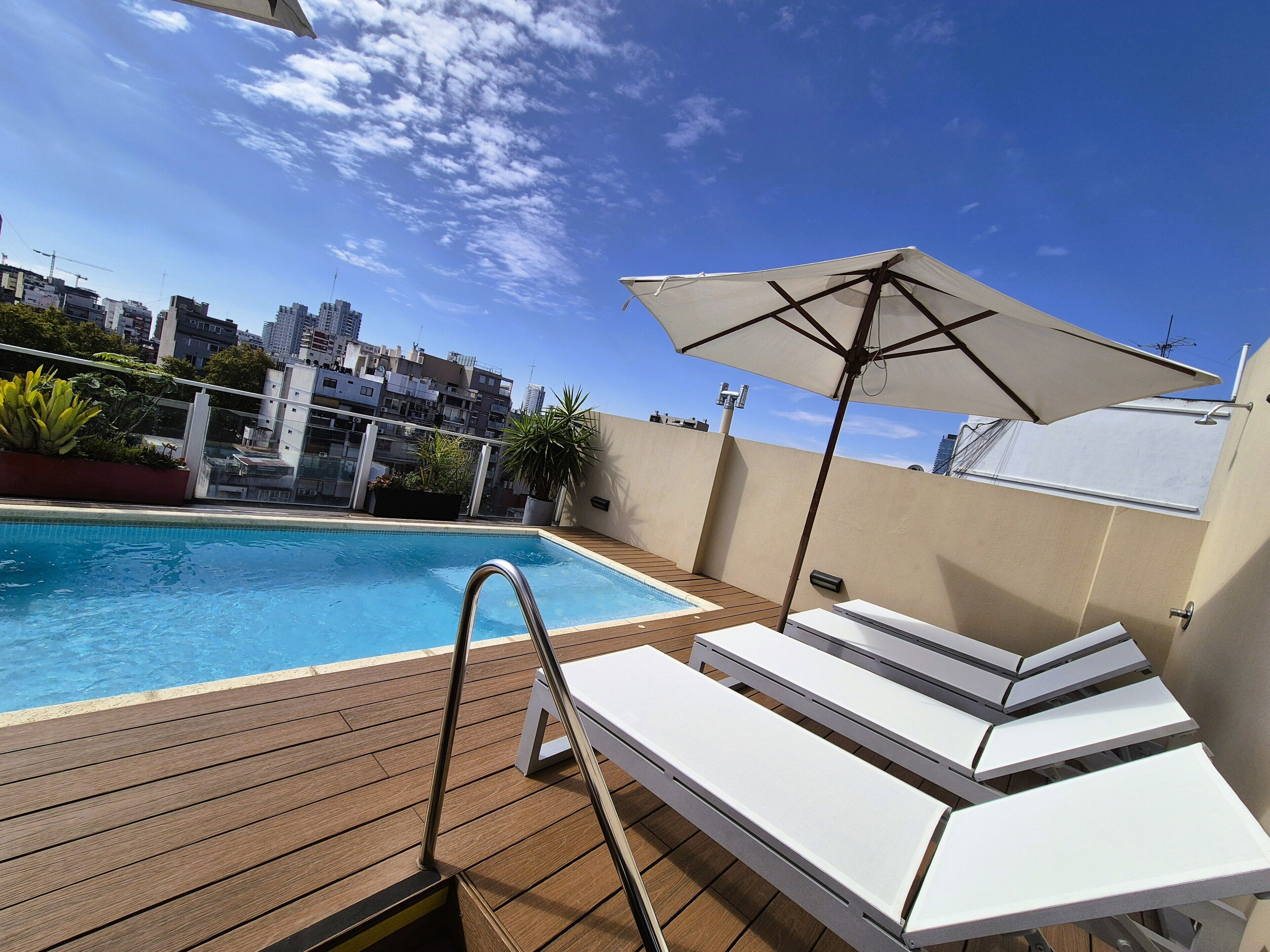 室外游泳池，池畔遮阳伞，日光浴躺椅