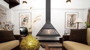 Ein Wohnzimmer mit Kamin, zwei Sofas, einem Couchtisch und Dekorationselementen.