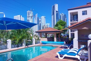 Outdoor pool, a heated pool, pool umbrellas, sun loungers - Chevron Palms Holiday Apartments by Gold Coast Premium (Surfers Paradise)