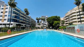 Een seizoensgebonden buitenzwembad, parasols voor strand/zwembad